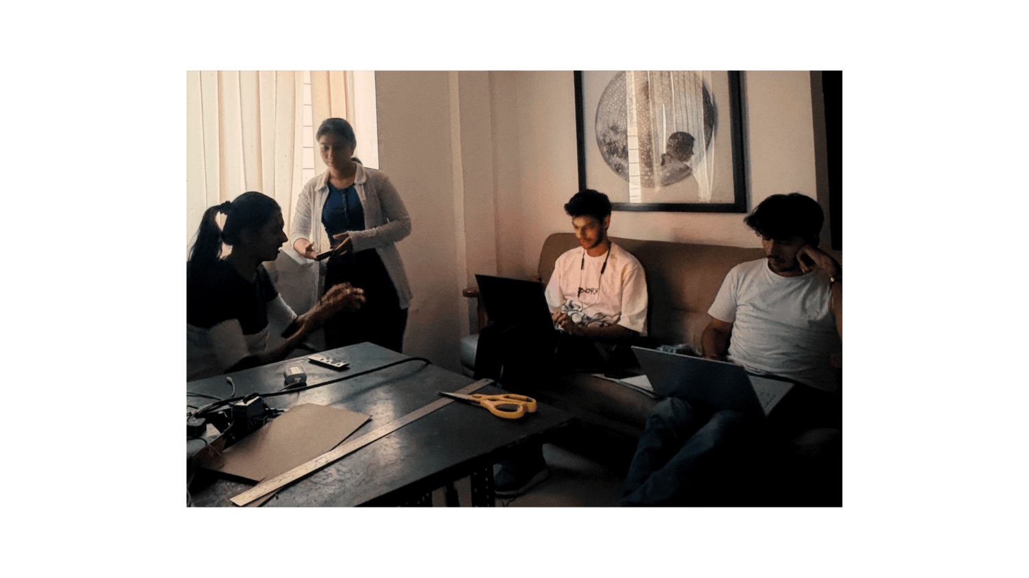 Group of people working together in a room with computers and documents.